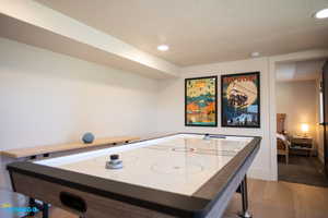 An air hockey table is located in the kitchen/dining/recreation room and you can see the entrance to the second bedroom in the basement ADU.