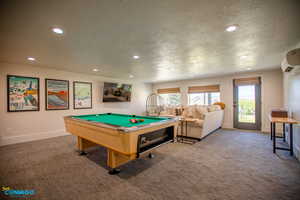 The basement living room includes a half bath, breakfast (or wet) bar, pool table, and lounging furniture. There is also a locked closet where the owner keeps all consumable supplies.