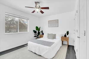 Bedroom featuring ceiling fan, baseboards, and wood finished floors