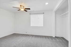 Carpeted spare room with ceiling fan, baseboards, visible vents, and recessed lighting