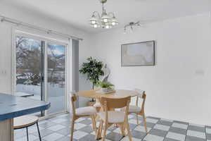 Dining space with light floors and a notable chandelier