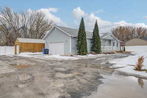 View of front of house with an attached garage and fence