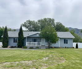 Ranch-style house with covered porch, a mountain view, and a shingled roof