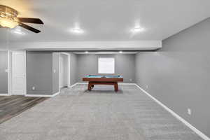 Playroom featuring baseboards, a ceiling fan, pool table, carpet flooring, and a textured ceiling