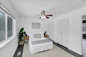 Bedroom featuring baseboards, visible vents, ceiling fan, and wood finished floors