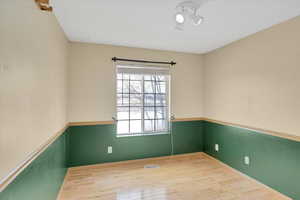 Empty room with visible vents and hardwood / wood-style floors