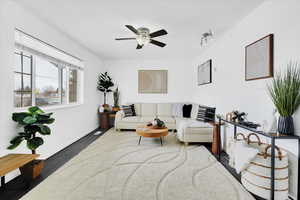 Living room with a ceiling fan, baseboards, and wood finished floors