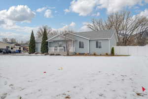 Single story home with covered porch and fence