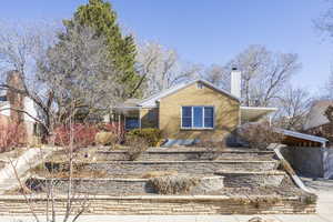 View of front of house with a chimney and brick siding