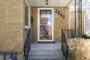 Property entrance featuring brick siding