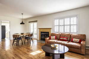 Living room featuring light wood finished floors, baseboards, a fireplace, and visible vents