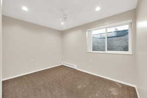 Spare room featuring a baseboard heating unit, carpet, baseboards, and recessed lighting