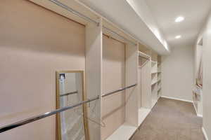 Spacious closet with light carpet