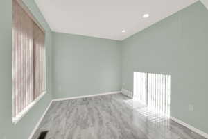 Empty room with baseboards, visible vents, and recessed lighting