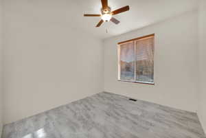 Spare room with baseboards, visible vents, and a ceiling fan