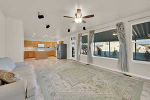 Living area with baseboards, visible vents, ceiling fan, and recessed lighting