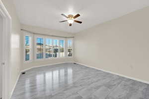 Empty room with ceiling fan and baseboards