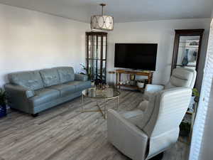 Living room with a notable chandelier and wood finished floors