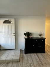 Foyer with light wood finished floors and baseboards