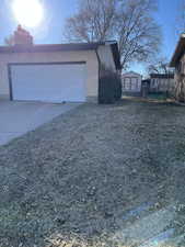 View of side of home featuring driveway, a chimney, and brick siding