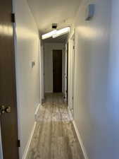 Hall featuring light wood finished floors and baseboards