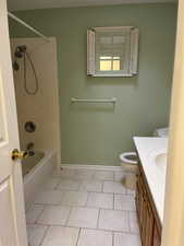 Bathroom with shower / bath combination, baseboards, toilet, tile patterned flooring, and vanity