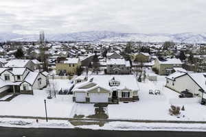 Snowy aerial view featuring a residential view and a mountain view