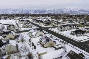 Snowy aerial view featuring a residential view and a mountain view