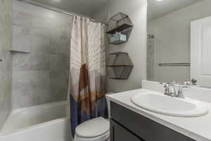 Full bathroom with shower / tub combo, vanity, and toilet