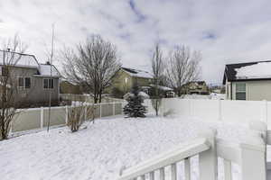 Snowy yard with fence private yard and a residential view