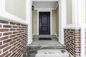 Doorway to property with brick siding