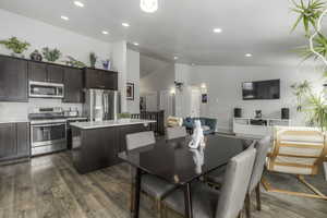 Dining room with high vaulted ceiling, recessed lighting, dark wood-style flooring, and visible vents