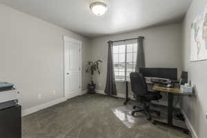 Home office featuring light colored carpet and baseboards