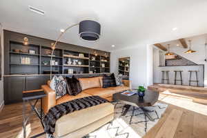 Living room with recessed lighting, visible vents, and hardwood / wood-style flooring