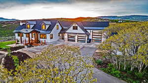 View of front of property with metal roof, a mountain view, a garage, driveway, and a standing seam roof