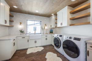 Laundry room featuring wooden ceiling, recessed lighting, a sink, cabinet space, and washer and clothes dryer