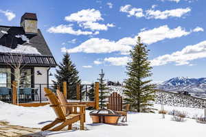 Snow covered playground featuring an outdoor fire pit and a mountain view