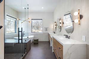 Full bathroom featuring wainscoting, vanity, and a wealth of natural light