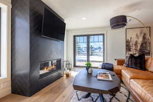 Living room featuring a large fireplace, visible vents, wood finished floors, and recessed lighting