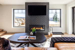 Living area with a large fireplace, stairway, wood finished floors, and baseboards