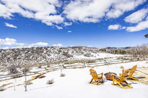 Snowy yard featuring an outdoor fire pit and a mountain view