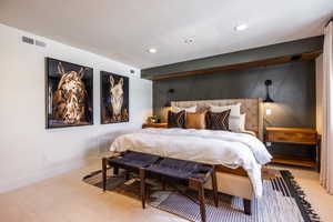 Bedroom with light carpet, visible vents, and baseboards