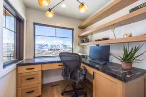 Office area with visible vents, wood finished floors, and built in study area