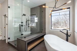 Full bath with tile walls, a freestanding tub, and a shower stall