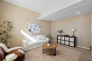 Carpeted living area featuring recessed lighting and baseboards