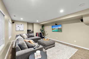 Carpeted living room with recessed lighting, visible vents, and baseboards