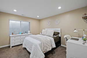 Bedroom featuring baseboards, visible vents, and dark colored carpet