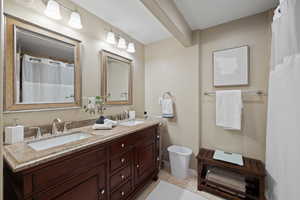 Full bath with tile patterned floors, a sink, and double vanity