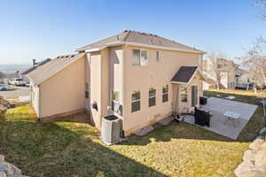 Back of property featuring a yard, stucco siding, a patio area, and central air condition unit