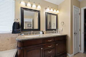 Full bathroom featuring double vanity and a sink